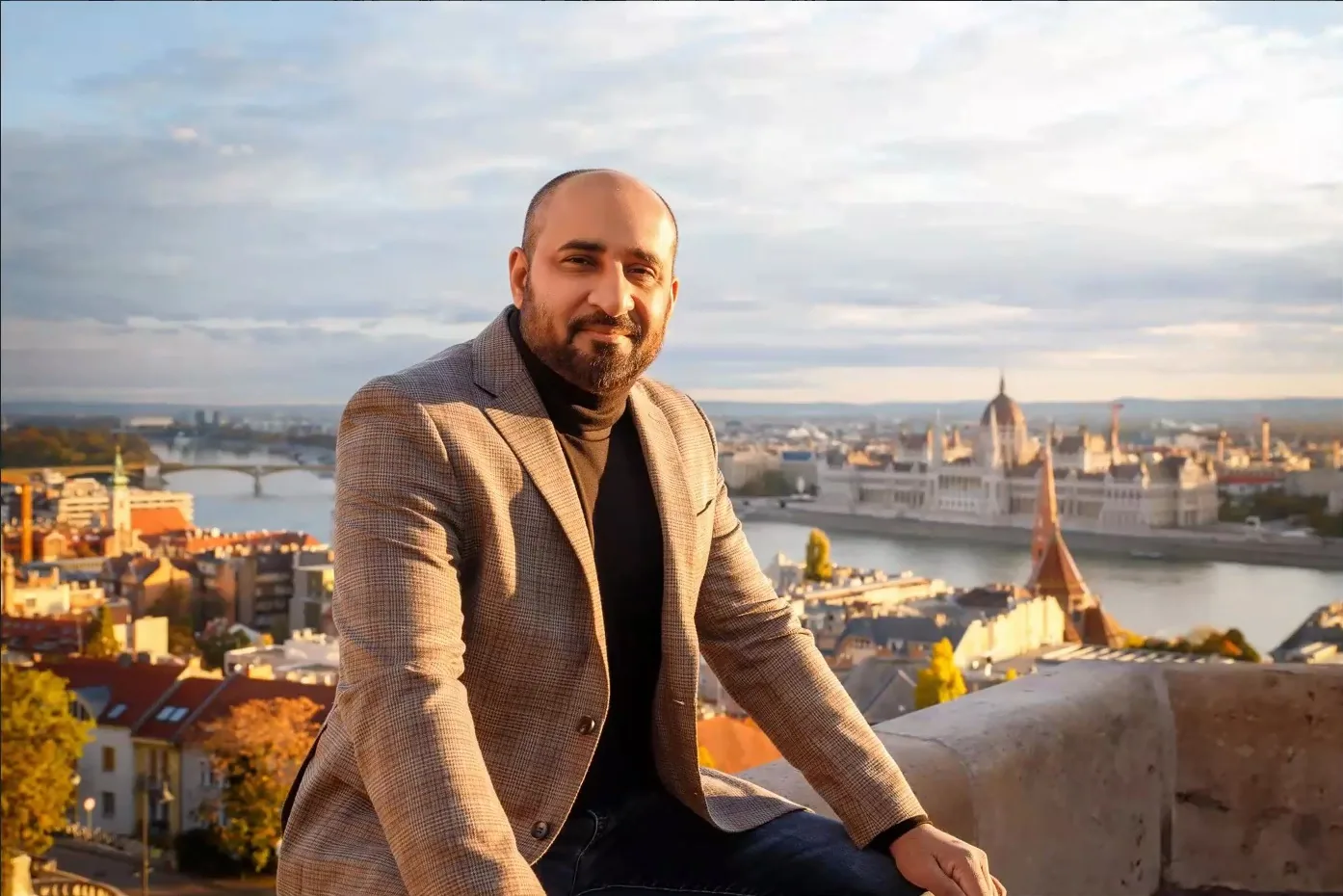 Ali Gulzari, CPA, EA, above the Danube in Budapest, with the Hungarian Parliament behind him.